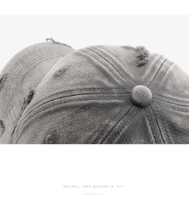 Macro shot of dark grey washed baseball cap showing vintage distressed texture and stitching