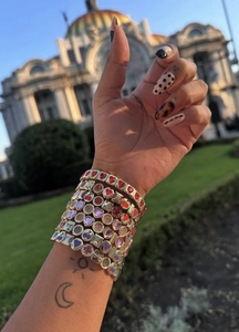 Gros plan de bracelets élastiques en zircon coloré empilés sur un poignet