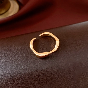 Macro shot of polished 18k gold plated irregular wave ring with an open adjustable design