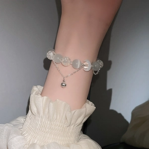 Detail eines Perlenarmbandes mit Opalperlen, Mond-Element und kleinem Glockenanhänger