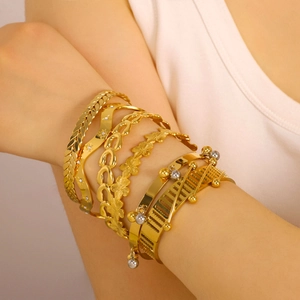 Set of gold geometric stainless steel bracelets featuring wave and chain design textures