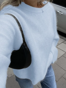 Women's chic light blue long-sleeved knit sweater paired with a black underarm bag