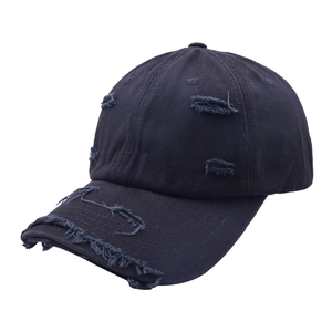 Détail de la visière usée et du tissu déchiré sur la casquette de baseball noire vintage