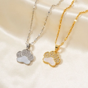 Luxurious gold and silver bear paw pendants with sparkling zircon inlay on silk background