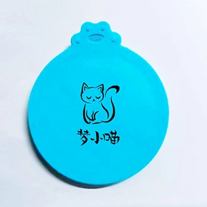 Close-up of blue silicone pet can lid with cat-shaped handle and printed cat illustration