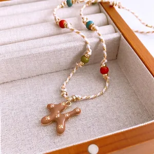 Handcrafted bohemian necklace with colorful beads and patterned brown ceramic pendant