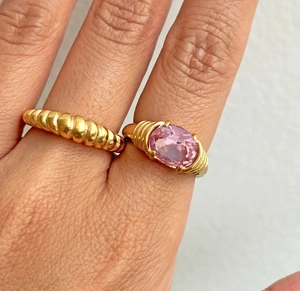 Close-up of 18k gold plated stainless steel rings with pink gemstone on female hand