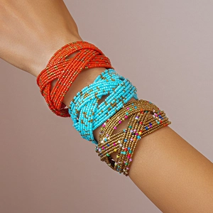 Close-up of bohemian multi-layer woven glass bead bracelets in red, blue, and gold tones