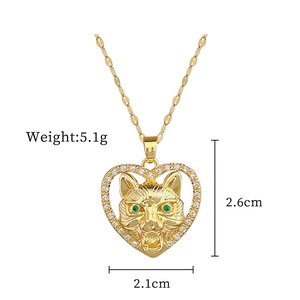 Close-up of golden heart pendant with a wolf head detail and green gemstone eyes