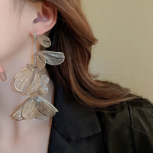 Macro view of silver hollow floral petal tassel earrings with multilayered metallic design
