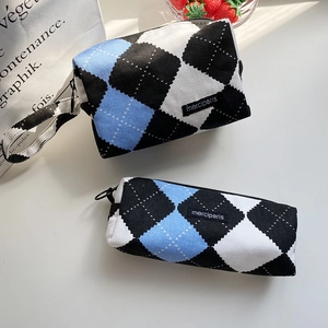 Detalle del set de neceser y estuche de lona con diseño de rombos azul y negro tejido