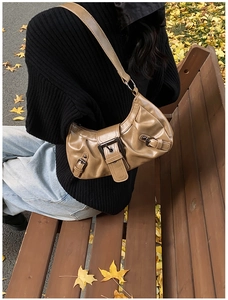 Detailed view of khaki pleated leather shoulder bag with vintage metal buckle
