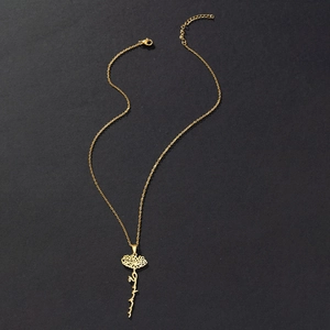 Detail of gold stainless steel necklace with Arabic calligraphy and floral flower pendant
