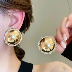 Chunky gold dome stud earrings with sparkling crystals edge for a bold fashion look