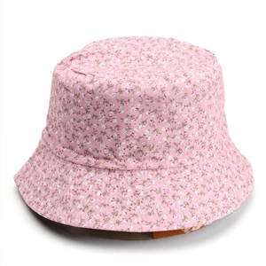 Detail of floral bucket hat featuring pink fabric with white flower pattern and green leaves