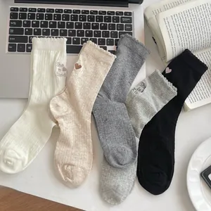 Detail of five pairs of heart-embroidered mesh crew socks in assorted neutral tones