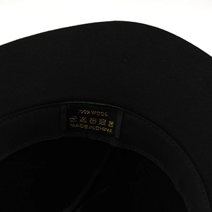 Detailed view of black wool bucket hat interior featuring the 100% pure wool washing label