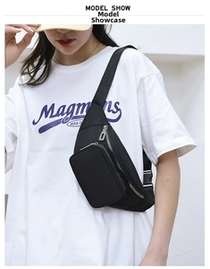 Close-up of a black waterproof nylon waist bag with adjustable strap shown on model