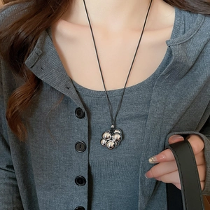 Dettaglio del ciondolo geometrico minimalista in argento su una collana a cordoncino