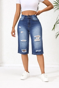 Gros plan sur le bermuda en jean bleu à taille haute pour femme avec détails effilochés