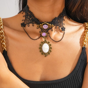 Detail eines Gothic-Spitzenhalsbands mit lila Edelstein und Vintage-Kamee-Anhänger in Gold