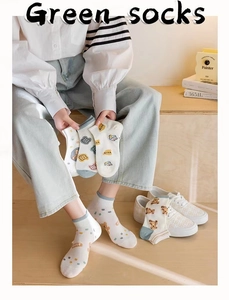 Close-up of cute cartoon bear prints and polka dots on breathable cotton ankle socks