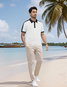 Polo à manches courtes avec col et poignets noirs contrastés sur une plage tropicale