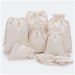 Various sizes of natural beige cotton drawstring bags arranged on a white background