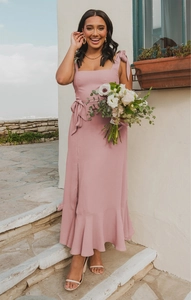 Detailed view of dusty pink maxi dress featuring shoulder bows and ruffled hemline