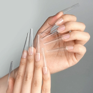 Detailed view of extra-long transparent coffin ballet nail tips on a female hand