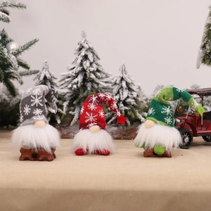 Three Christmas gnomes with knitted snowflake hats and LED lights on a festive background
