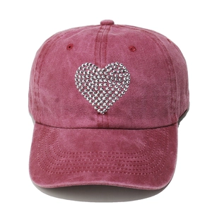 Macro detail of pink washed cotton baseball cap with sparkling rhinestone heart design