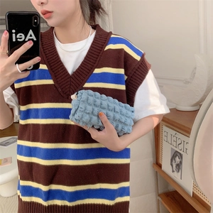 Close-up of blue bubbly textured storage bag held by a model with soft fabric detail