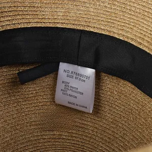 Detailed view of straw hat inner lining featuring size tag and paper fiber texture