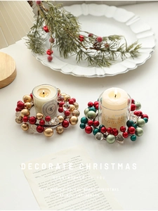 Detail of red and green Christmas berry wreath candle holder for festive table decor