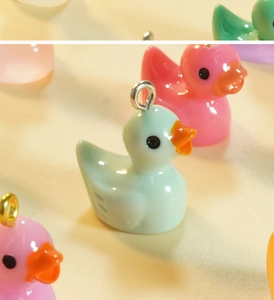 Macro shot of colorful resin duck charms with metal loops for DIY jewelry making