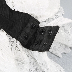 Detail of three-row snap fastener closure on white lace and black ribbed bodysuit fabric