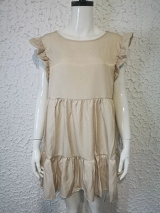 Detailed view of the apricot ruffle sleeve layered hem dress on a display mannequin