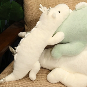 Close-up of soft plush white dragon pillow with silky scales on a cozy beige sofa