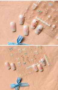 Detail of French lace nail stickers with embossed floral and bow designs in soft pink