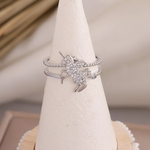 Macro detail of silver unicorn ring with pavé cubic zirconia on jewelry stand