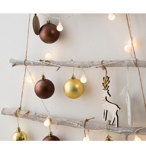 Festive wood branch wall decor with gold ornaments, reindeer pendants, and LED lights