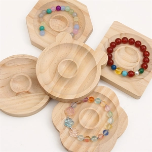 Macro detail of various geometric and bear-shaped pine wood bead display trays in natural finish