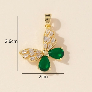 Detail view of gold butterfly pendant with white baguette diamonds and green gemstones