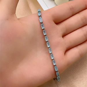 Close-up of light blue rectangular zircon stones set in a silver-tone tennis bracelet