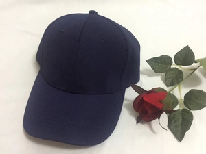 Classic deep blue six-panel cotton baseball cap with curved brim on white fabric background