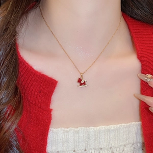 Detail of gold plated necklace featuring a red rocking horse pendant with cubic zirconia