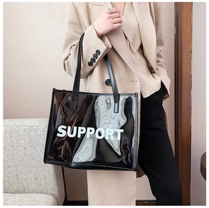 Close-up of black glossy jelly tote bag with white SUPPORT text shown on a model