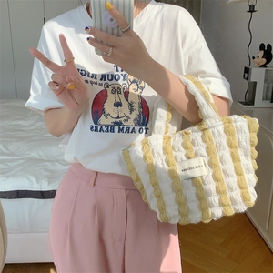Detail view of yellow and white striped bubble canvas tote bag with textured puckered fabric
