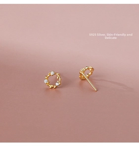 Macro detail of S925 silver gold wreath earrings with zircon leaves on pink background